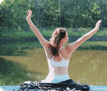 Woman doing yoga pose by the lake